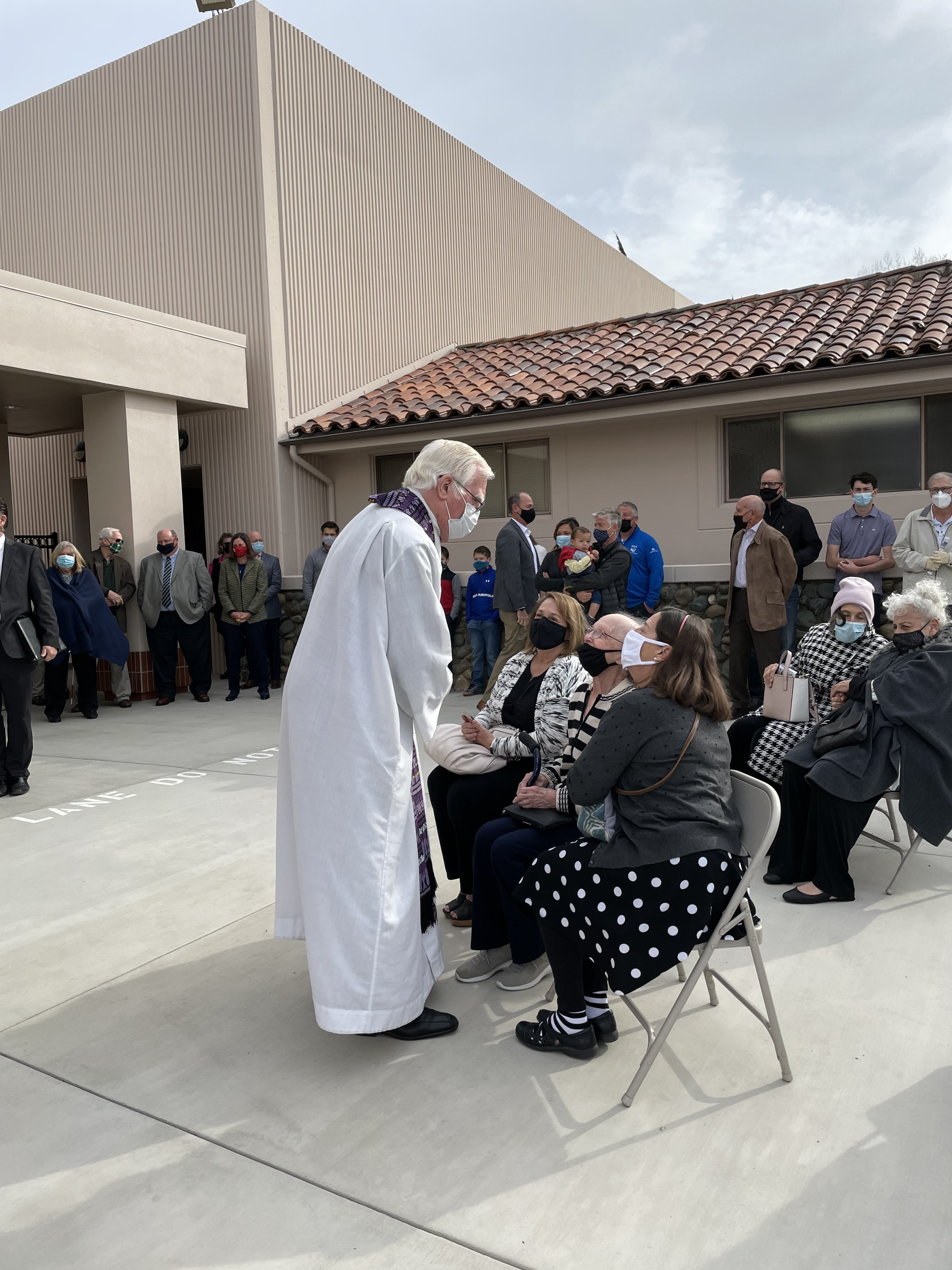 Fr. Brendan McKeefry greets Nancy Affinto and her family before the ceremony.